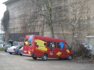 Das Kinderbüro unterwegs, ein roter Kleintransporter, am Eugen-zur-Nieden-Ring in Oberhausen-Sterkrade.